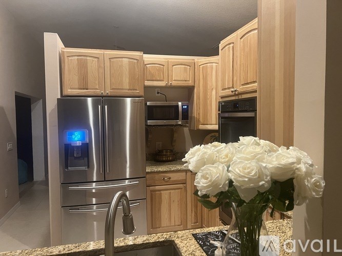 A kitchen with wooden cabinets and a stainless steel refrigerator.