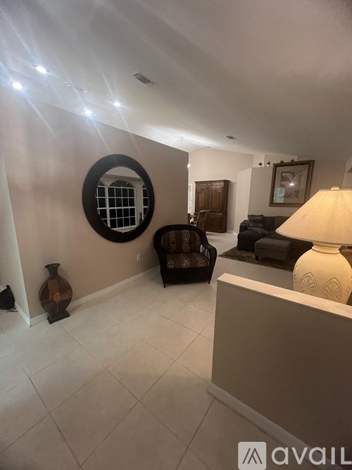 A living room with a round window and a lamp.