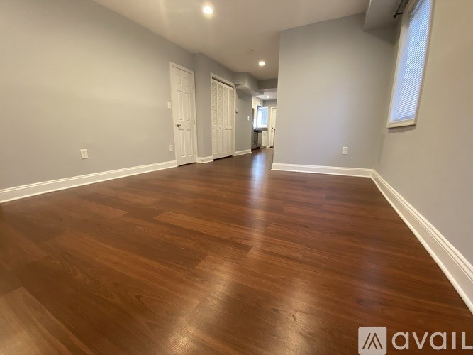 A room with wooden flooring and white walls.