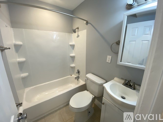 A white bathroom with a toilet, sink, and bathtub.
