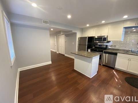 A kitchen with white cabinets and a granite countertop.