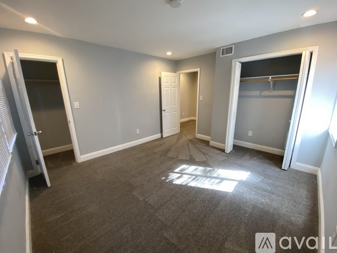 A room with a carpeted floor and a door on the left side.
