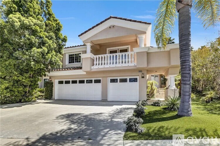 A two-story house with a balcony and a garage.