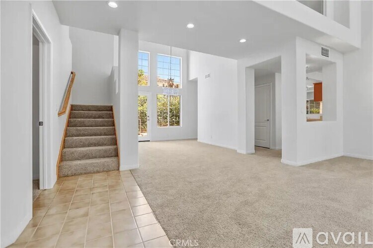 A spacious living room with a staircase leading to the upper floor.