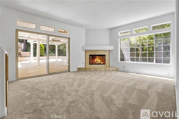 A living room with a fireplace and a carpet.