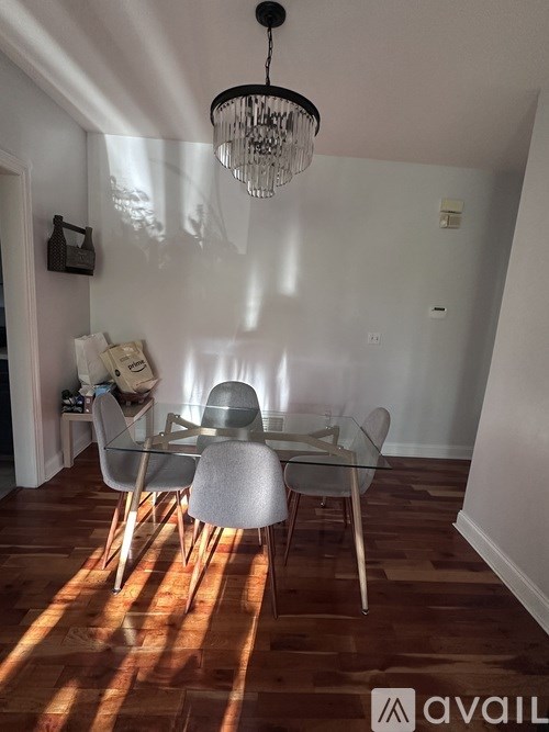 A dining room with a glass table and chairs.