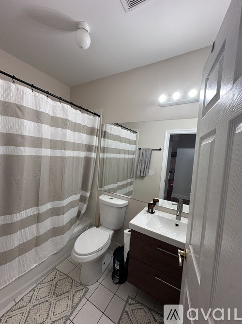 A bathroom with a toilet, sink, and shower curtain.