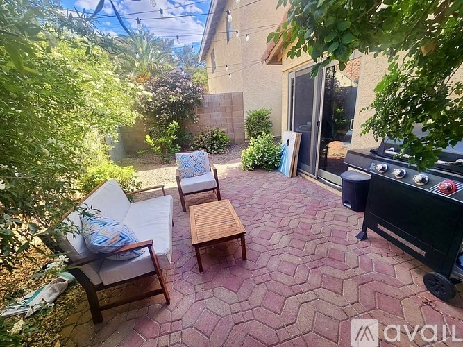 A patio with a grill and chairs.