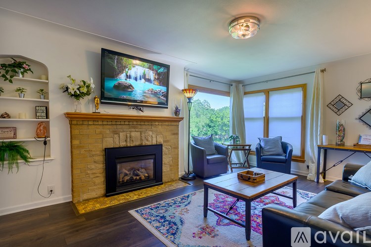 A living room with a fireplace and a television on the wall.