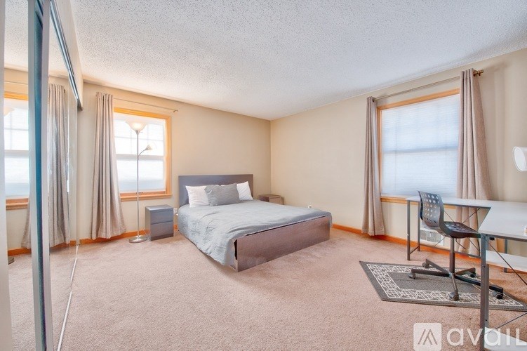 A bedroom with a bed, desk, and chair.