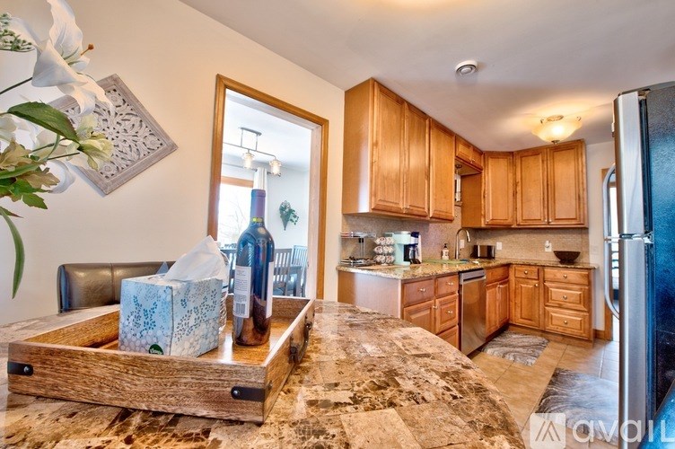 A kitchen with wooden cabinets and a marble countertop.