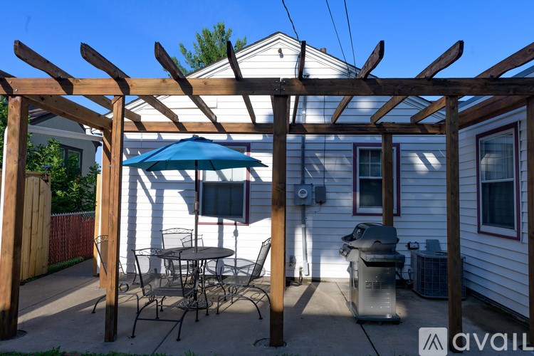 A patio with a table and chairs under a pergola.