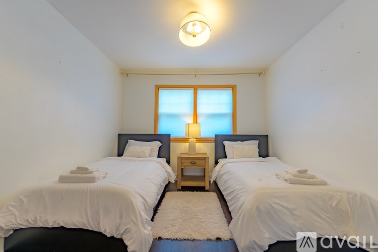 Two beds in a room with a window and a nightstand.