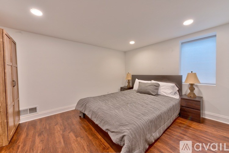 A bedroom with a bed, nightstand, and lamp.