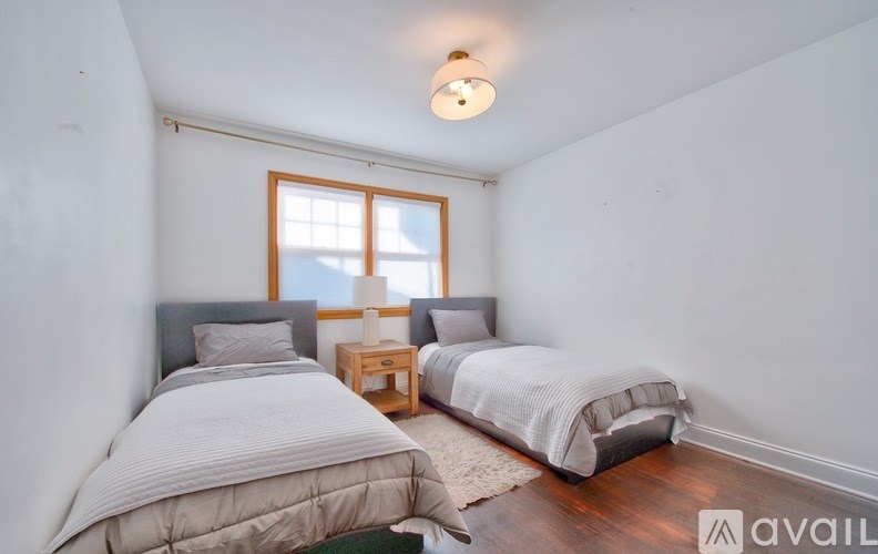 Two beds in a room with a window.