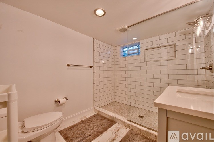 A bathroom with a toilet, sink, and shower.