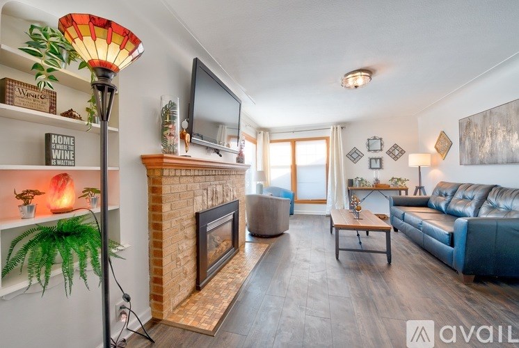 A living room with a fireplace and a blue couch.