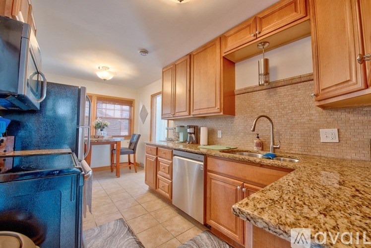 A kitchen with wooden cabinets and granite countertops.