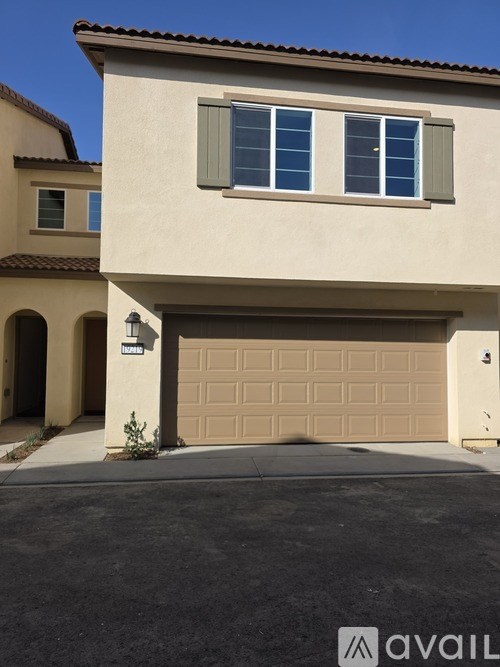 A beige house with a brown garage door.