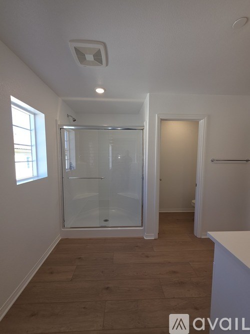 A room with a glass door and wooden flooring.