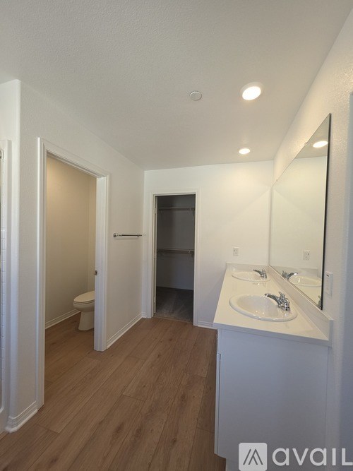 A bathroom with a toilet, sink, and mirror.