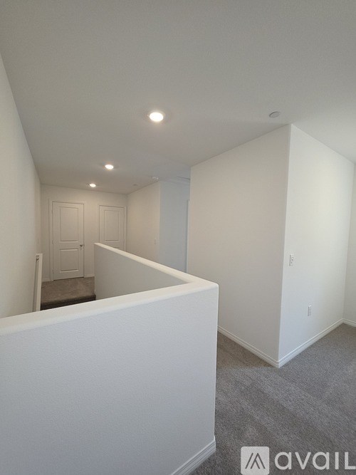 A white room with a carpeted floor and a door in the background.