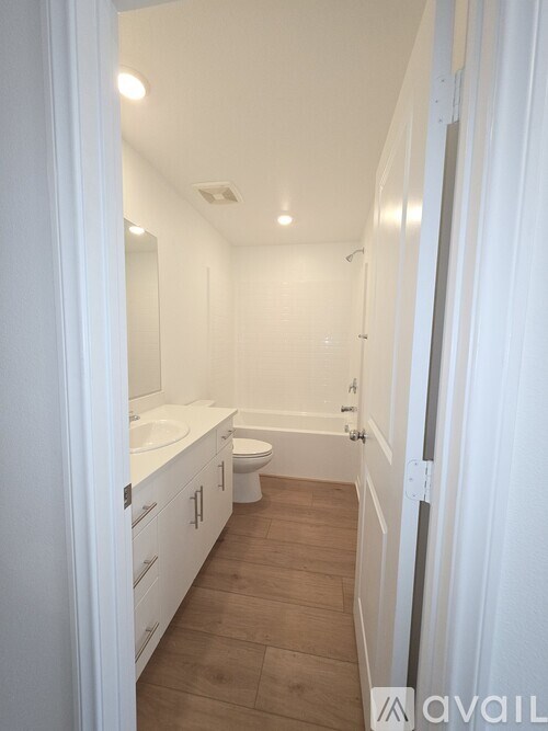 A bathroom with a toilet, sink, and mirror.