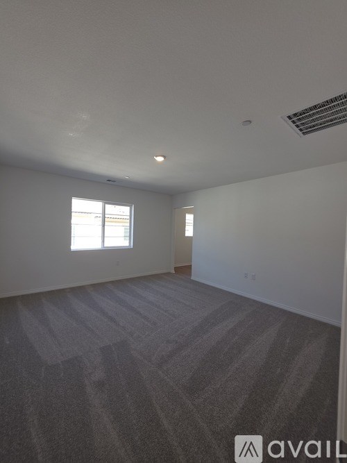 A room with a carpeted floor and a window letting in natural light.