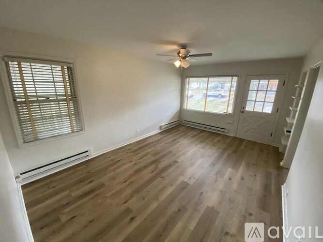 A room with wooden flooring and a ceiling fan.