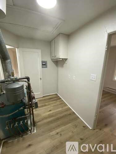 A room with a white wall and a door.