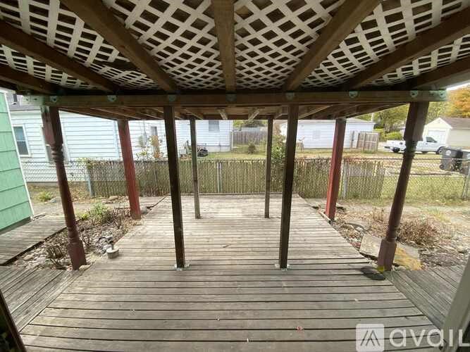 A wooden deck with a lattice roof and red posts.