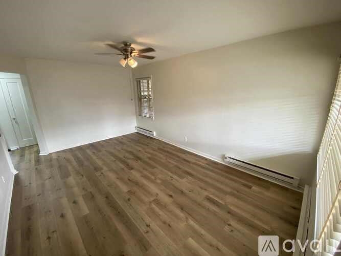 A room with wooden flooring and a ceiling fan.