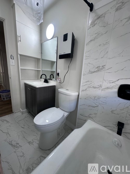 A bathroom with a toilet, sink, and bathtub.