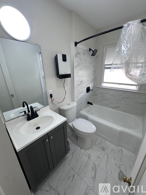 A bathroom with a sink, toilet, and bathtub.