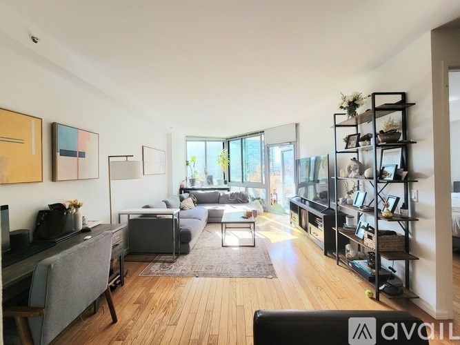 A living room with a grey couch and a wooden floor.