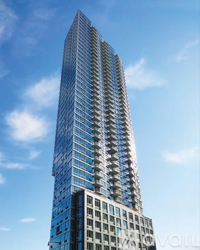 A tall skyscraper with a blue sky in the background.