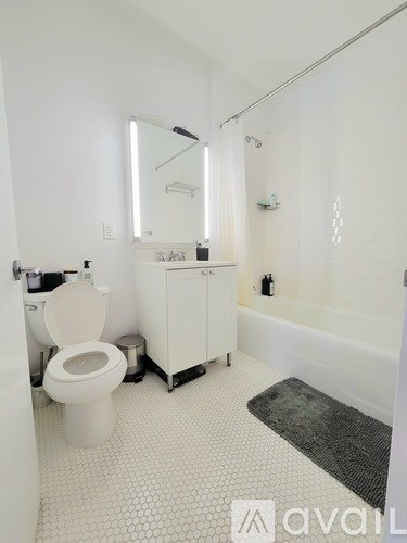 A white bathroom with a toilet, sink, and mirror.