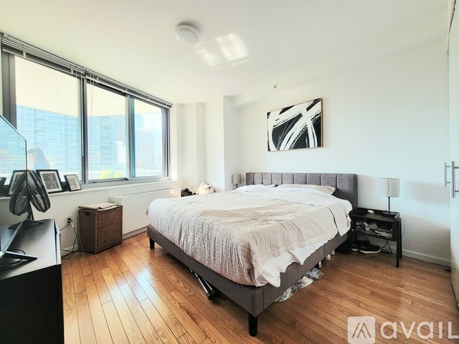 A bedroom with a large bed and a desk with a computer monitor.