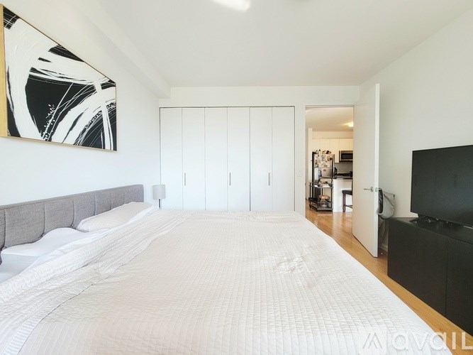 A bedroom with a large bed and a television.