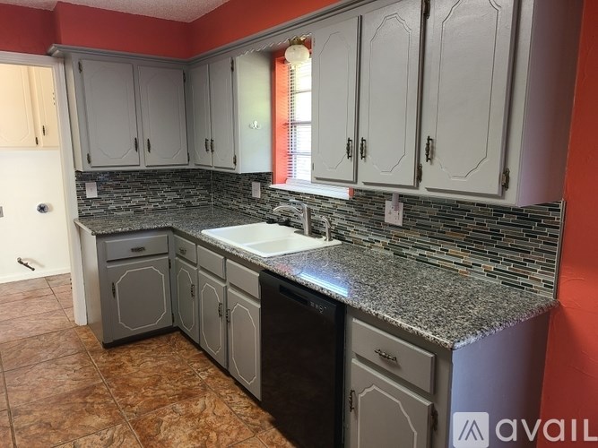 A kitchen with a granite countertop and a dishwasher.
