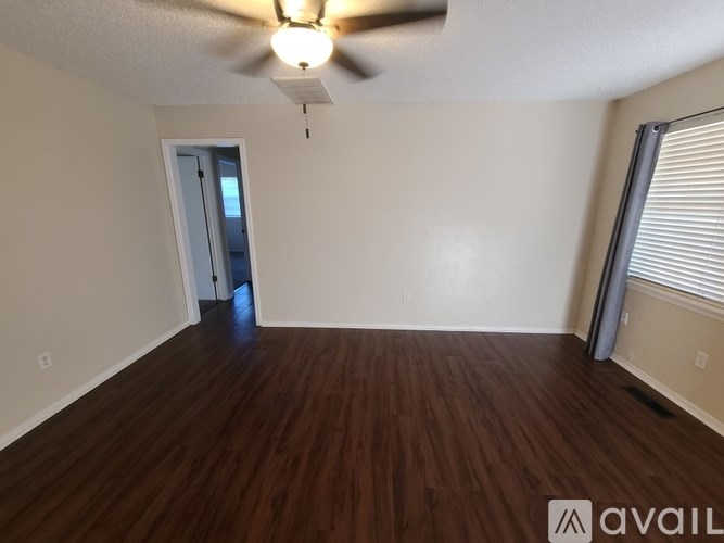A room with wooden flooring and a ceiling fan.