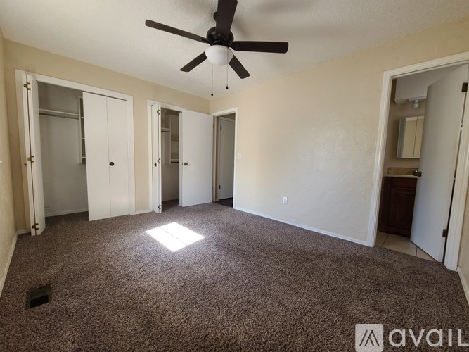 A room with a ceiling fan and carpeted floor.