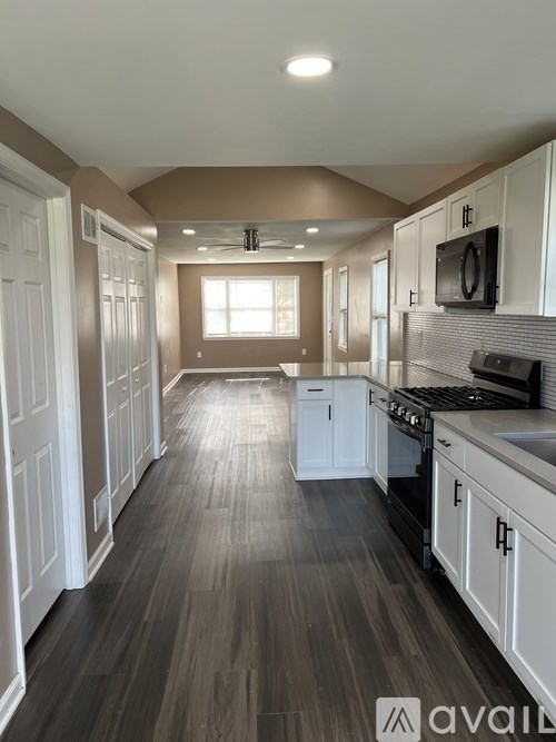 A kitchen with white cabinets and a black stove top oven.