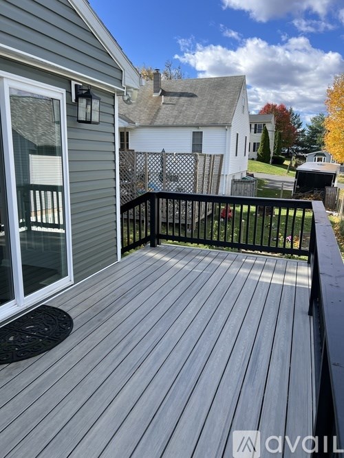 A deck with a black railing and a white door.