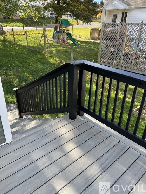 A deck with a black railing and wooden floor.