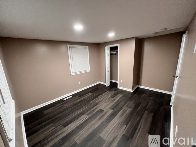 A room with wooden flooring and a white door.