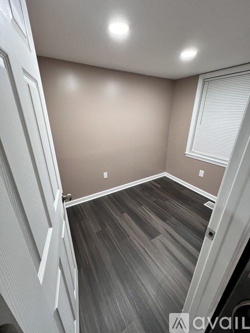 A room with wooden flooring and white walls.