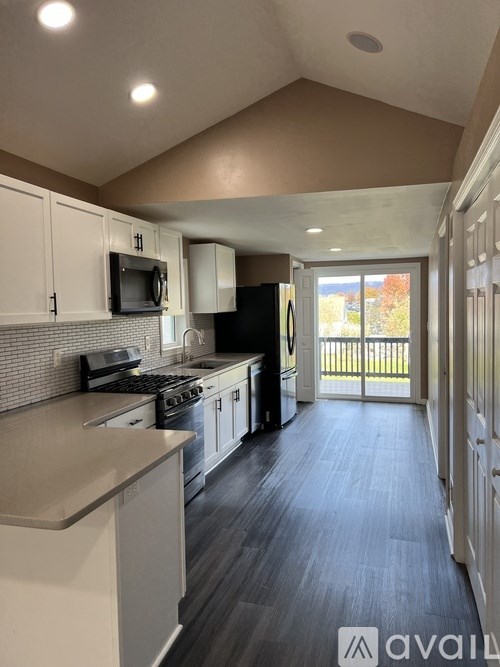 A kitchen with a refrigerator, microwave, oven, and stove.