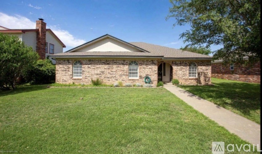 A house with a green lawn and a white fence.