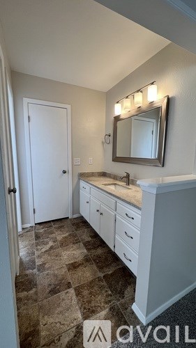 A bathroom with a tiled floor and a white vanity.